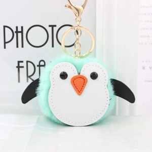 Détail d'un porte-clés pingouin en peluche vert menthe avec fermoir doré et fourrure