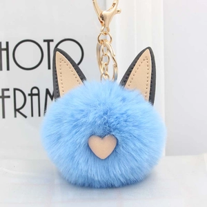 Détail du porte-clés pompon bleu ciel avec oreilles de chat et fermoir doré en alliage