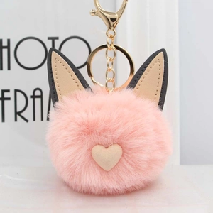 Gros plan du porte-clés chat en peluche rose avec oreilles en cuir et fermoir doré