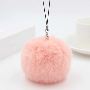 Close-up of a soft pink faux rabbit fur pom pom charm with silver ring and lanyard