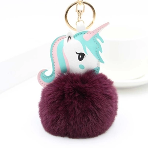 Détail du porte-clés licorne en peluche avec pompon violet et fermoir mousqueton doré