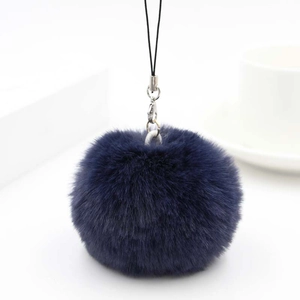 Detail of dark blue plush faux rabbit fur pom pom keychain with silver lobster clasp