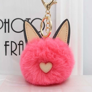 Gros plan d'un charmant pompon oreilles de chat rose avec cœur et fermoir doré