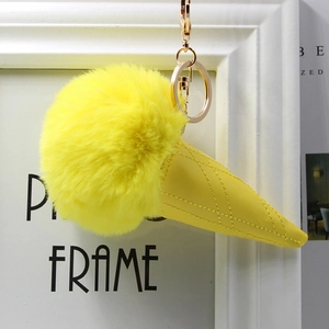 Macro detail of ice cream plush keychain with yellow faux fur and quilted leather cone