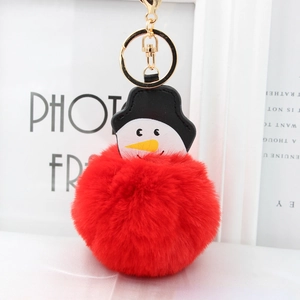 Détail du porte-clés pompon bonhomme de neige rouge avec cuir noir et fermoir doré chic