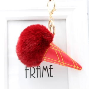 Close-up of fluffy red faux fur ice cream keychain with gold clasp and yellow stitching