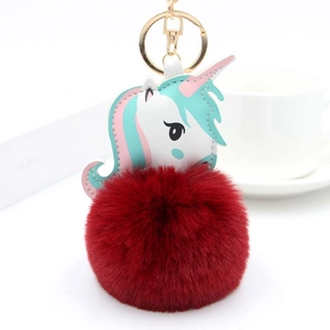 Détail d'un porte-clés licorne en peluche rouge foncé avec anneau en métal doré