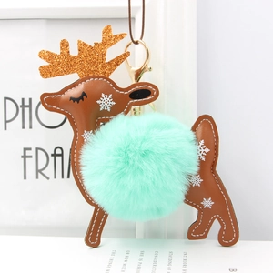Detail of reindeer keychain featuring mint green faux fur pompom and brown leather texture