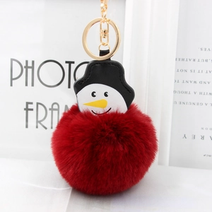 Détail d'un porte-clés bonhomme de neige en fausse fourrure rouge avec fermoir métallique doré