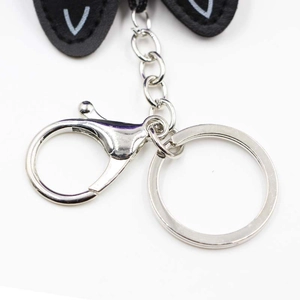 Close-up of polished silver lobster clasp and metal ring on black leather kitten charm
