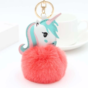 Détail du porte-clés licorne en peluche avec pompon rose et anneau en métal doré