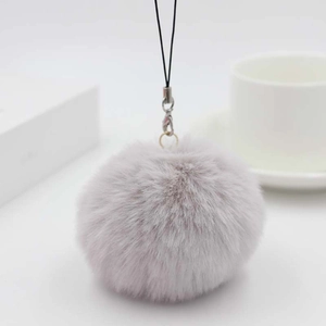 Close-up of soft purple faux fur pompom keychain with silver metal lobster clasp detail