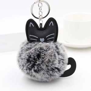 Detail showing the fluffy two-tone faux fur kitten keychain with embroidery and metal clip