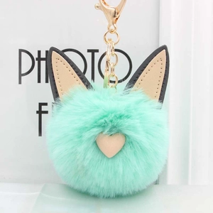 Détail macro du porte-clés chat en peluche vert menthe avec fermoir doré et oreilles