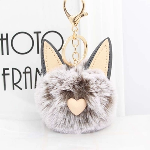 Détail du porte-clés pompon oreilles de chat avec ornement cœur et fermoir doré brillant