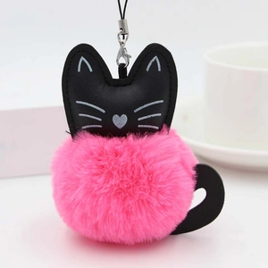 Détail du porte-clés chat en peluche avec pompon rose et tête en cuir noir décorative