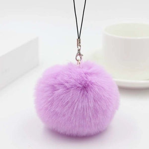 Close-up of fluffy purple faux rabbit fur pompom charm with silver lobster clasp and black cord
