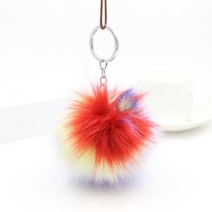 Detail of colorful fluffy faux fur pompom keychain with silver metal ring and strap