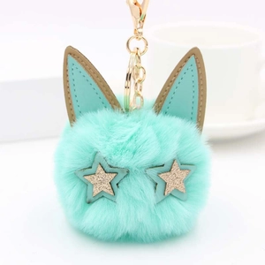 Détail du pompon peluche vert menthe avec oreilles de chat et porte-clés doré chic