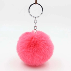 Close-up of fluffy magenta faux rabbit fur pom pom with silver metal keychain ring