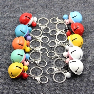Detailed overhead view of various colorful cat-face metal bell pendants with lobster clasps