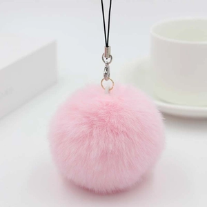 Macro view of pink faux rabbit fur pom pom keychain with black lanyard and lobster clasp