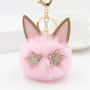 Détail du porte-clés pompon chat en fausse fourrure rose avec étoiles dorées et clip métal