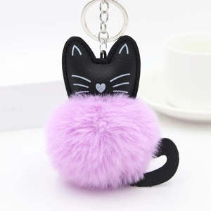 Close-up of a fluffy purple pom-pom cat keychain with black leather ears and tail