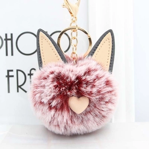 Gros plan sur un porte-clés pompon oreilles de chat en fausse fourrure rouge-rose