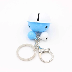 Detail of blue and white metal bell keychain with star cutout and silver lobster clasp
