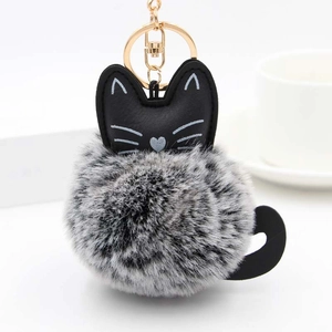 Detail of creative gray and white plush lucky cat keychain with golden metal clasp