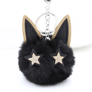 Porte-clés chat en peluche noire avec yeux étoiles dorées sur fond blanc immaculé