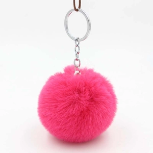 Close-up of fluffy rose red faux rabbit fur pom pom keychain with silver metal clasp