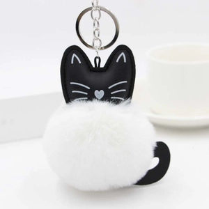 Detailed view of black cat leather charm with fluffy white faux fur pompom and silver ring