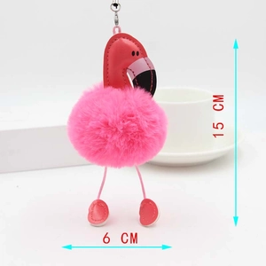 Porte-clés flamant rose en peluche, dimensions 15cm x 6cm à côté d'une tasse blanche