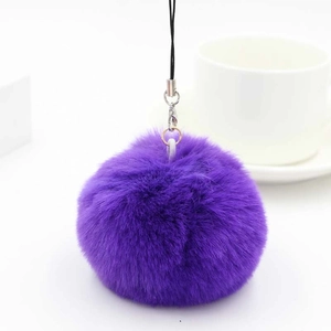 Detailed view of a soft purple faux rabbit fur pom pom keychain with a black lanyard