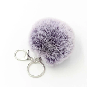 Macro detail of purple faux rabbit fur pom pom with silver metal keyring and lobster clasp