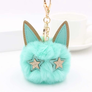 Détail du porte-clés chat en peluche vert menthe avec yeux étoiles dorées et oreilles PU