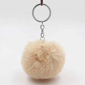 Close-up of fluffy beige faux rabbit fur pom pom keychain with silver metal ring