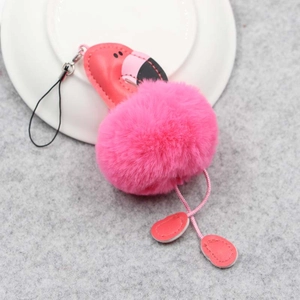 Détail d'un porte-clés flamant rose en peluche sur assiette blanche avec fermoir métal