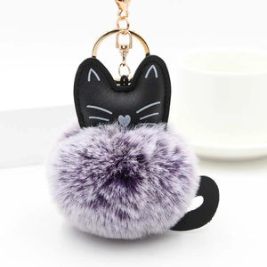 Detail of cute purple fluffy cat keychain with golden metal clasp and black feline ears