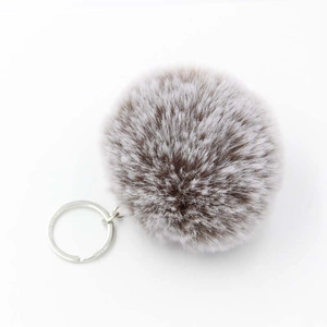 Close-up of 8cm fluffy taupe and white faux fur pompom keychain with silver metal ring