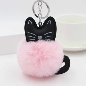 Close-up of pink fluffy cat pompom keychain with cat ears and silver metal keyring