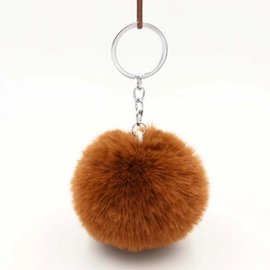 Caramel brown plush pompom keychain with silver metal ring on white background