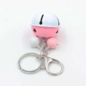 Detailed view of pink and white metal bells with star cutouts and silver lobster clasp