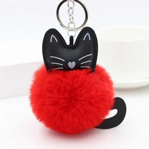 Detailed view of the bright red faux fur cat pompom keychain with silver metal hardware