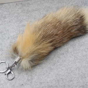 Macro shot of fluffy brown fox tail keychain with a secure silver metal spring clasp