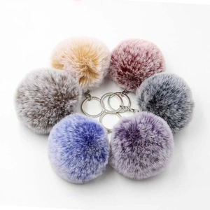 Detail view showing six colorful 8cm faux rabbit fur pom pom keychains for bags