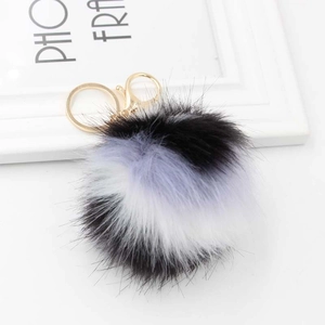 Détail du porte-clés pompon tricolore en noir violet et blanc avec anneau en métal doré