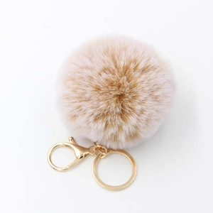 Detailed view of fluffy faux rabbit fur pom pom keychain with gold lobster clasp and ring